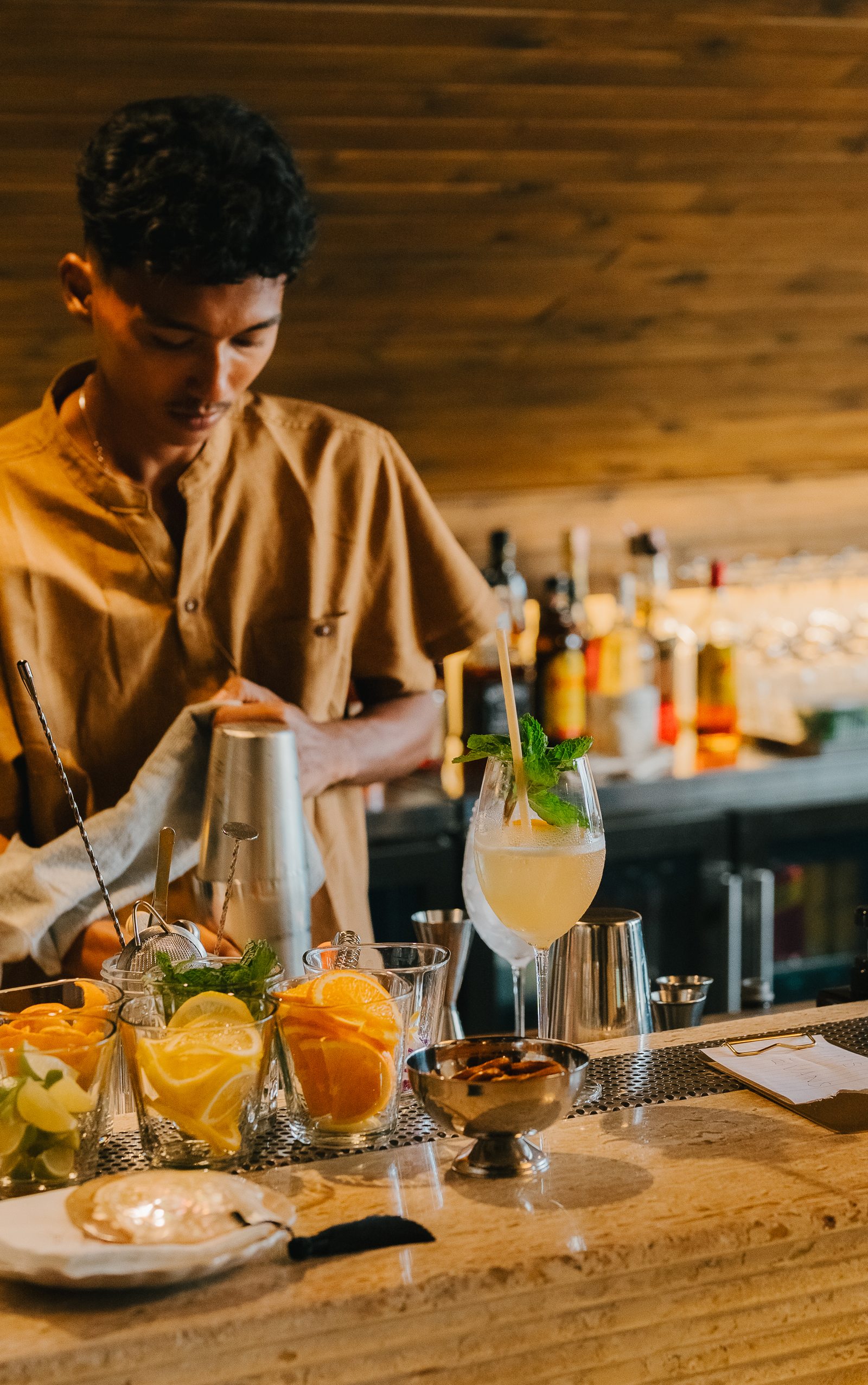 Bartender preparing a cocktail with fresh citrus at Soirée, Bangrak